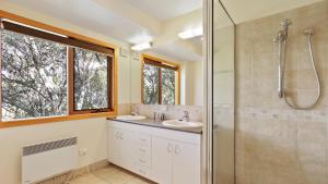 a bathroom with two sinks and a glass shower at Jasandre in Dinner Plain +10 photos