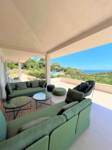 un salon avec un canapé vert et des tables dans l'établissement Villa A Muredda, à Sainte-Lucie de Porto-Vecchio