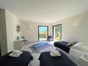 Cette chambre blanche dispose de deux lits et d'une fenêtre. dans l'établissement Villa A Muredda, à Sainte-Lucie de Porto-Vecchio 36 autres photos