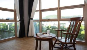 einen Tisch und zwei Stühle in einem Zimmer mit Fenstern in der Unterkunft Ariana Hotel in Daegu