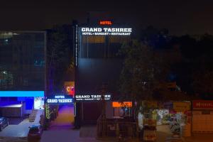a building with signs on the side of it at night at The Grand Tashree at Delhi Airport in New Delhi