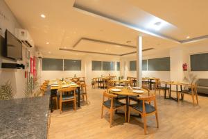 a dining room with wooden tables and chairs at The Grand Tashree at Delhi Airport in New Delhi