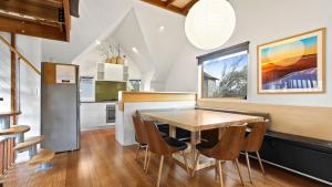 a kitchen and dining room with a wooden table and chairs at Dandongale in Dinner Plain