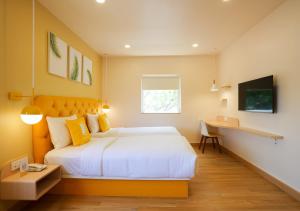 a bedroom with a large bed and a desk at Bloom Hotel Koramangala in Bangalore
