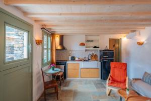 a small kitchen with a table and chairs and a counter at Houses at Chrisopigi Sifnos in Chrisopigi +37 photos