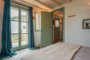 a bedroom with a bed and a large window at Houses at Chrisopigi Sifnos in Chrisopigi