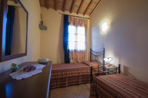 a bedroom with two beds and a window at Agriturismo Casetta I in Vinci