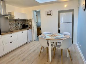 a kitchen with a table and chairs in a room at La Casa de la Mouette Rieuse in Eu