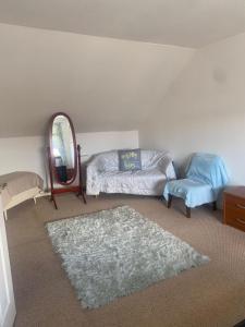 a living room with a bed and a mirror and a rug at Homely Apartment near the Beach with Mini Luxuries in Methil
