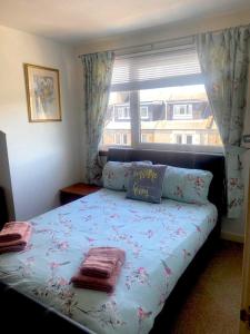 a bedroom with a bed with pillows and a window at Homely Apartment near the Beach with Mini Luxuries in Methil
