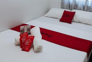 two beds with red and white sheets and pillows at RedDoorz Bunakidz Lodge El Nido Palawan in El Nido