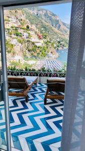 a balcony with two benches and a view of a mountain at Villa Diamond Luxury Suite in Positano