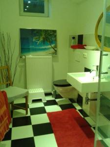 a bathroom with a black and white checkered floor at Strand & Garten in Surendorf