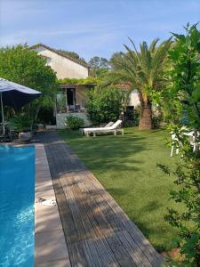 a backyard with a swimming pool and a table and a bench at Villa féeric in Toulon