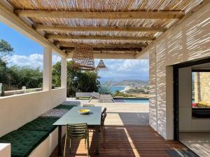 a patio with a table and chairs and a view of a pool at Villa Alandra in Pietrosella