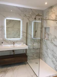 bagno con lavandino e doccia con specchio di Villa Alandra a Pietrosella