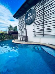 a swimming pool with a bench next to a building at Garden Apartments in Nadi