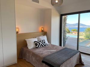 a bedroom with a bed with a view of the water at Villa Alandra in Pietrosella