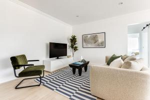 uma sala de estar com um sofá e uma televisão em Kahlo Bondi - Luxury Escape - 2 Bedroom Furnished Apartments em Sydney