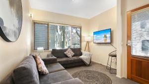 a living room with a couch and a table at Prosecco in Dinner Plain