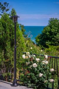 um poste de luz ao lado de um arbusto com rosas em Marina Sarafovo em Burgas