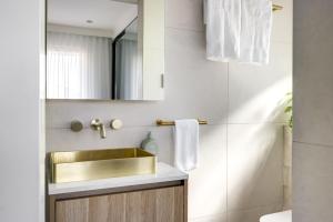 a bathroom with a gold sink and a mirror at Kahlo Bondi - Luxury Escape - 2 Bedroom Furnished Apartments in Sydney