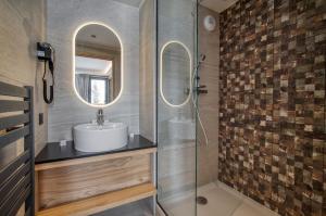 a bathroom with a sink and a mirror at Chalet Hôtel Turquoise in La Plagne Tarentaise