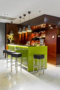 a kitchen with a green bar with stools at Zenit Don Yo in Zaragoza