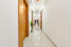 a corridor of a hospital with white tile floors and a hallway at FabHotel Elite Inn I in Ahmedabad