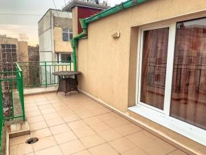 einen Balkon mit einem Tisch neben einem Gebäude in der Unterkunft Aпартамент в близост до морето и центъра in Burgas City