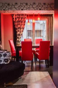 ein Esszimmer mit roten Stühlen und einem Tisch in der Unterkunft Aпартамент в близост до морето и центъра in Burgas City