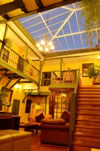 a living room with stairs and a glass ceiling at Hostal Mallqui in Cusco