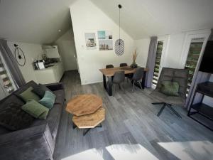 a living room with a couch and a table at Beachhouse Veluwemeer mit großem Garten in Strandnähe (inkl. Hallenbadnutzung) in Hulshorst