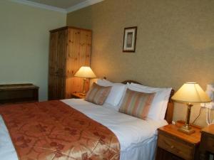 a bedroom with a large bed with two lamps at Towers Hotel Glenbeigh in Glenbeigh