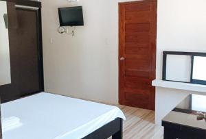 Habitación pequeña con cama y puerta en RedDoorz Covelandia Garden Resort Nueva Ecija, 