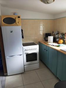a kitchen with a white refrigerator and a stove at Studio sur les hauteurs de La Ciotat vue mer in La Ciotat