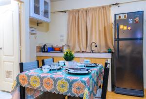 a kitchen with a table and a refrigerator at Kara's Condotels in Cebu City