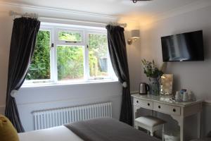 a bedroom with a bed and a window and a desk at The Mount Pleasant Hotel in Sidmouth