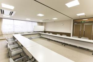 a large room with chairs and a whiteboard in it at Fujisan Station Hotel in Fujiyoshida