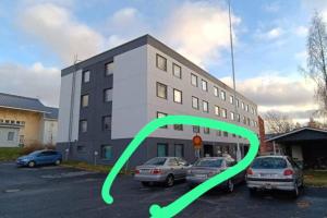 a building with cars parked in a parking lot at 2BR with sauna in Tornio city in Tornio