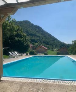a large swimming pool with a mountain in the background at Glamping Laško in Laško