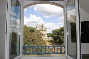 an open window with a view of a castle at Best Western Hotel du Chateau Maisons Laffitte in Maisons-Laffitte