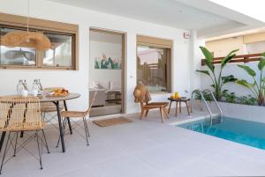 a living room with a table and a swimming pool at Mariann Premium Suites in Lardos