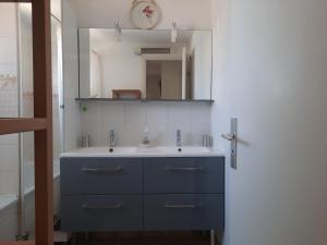 a bathroom with a blue sink and a mirror at Résidence les Sables D'or in Cap d'Agde +29 photos