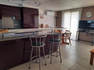 a kitchen with two bar stools and a counter at Résidence les Sables D'or in Cap d'Agde