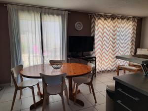 a living room with a table and chairs and a television at Résidence les Sables D'or in Cap d'Agde