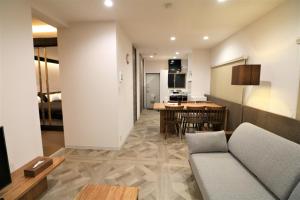 ein Wohnzimmer mit einem Sofa und einer Küche in der Unterkunft Smart Stay Ito 301 - Vacation STAY 98452 in Ito