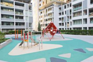 a playground in front of a large apartment building at 3BR Apt near Stadiums, Family-Friendly, Cozy decor in Sydney