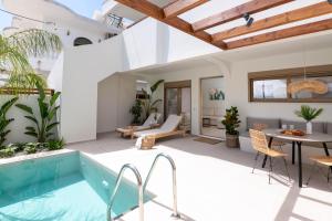a villa with a swimming pool and a patio at Mariann Premium Suites in Lardos