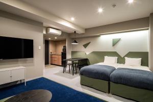 a bedroom with a bed and a flat screen tv at Section L Kuramae - Asakusa in Tokyo +37 photos
